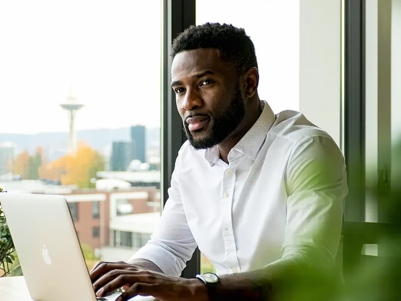 Founder working at a desk in a modern Seattle office environment, warm ambient lighting, focused atmosphere